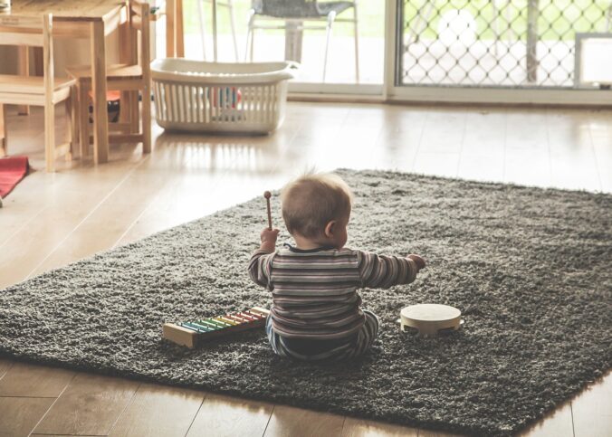 Un enfant assis sur un tapis.